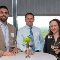 3 detroit attendees stand at table
